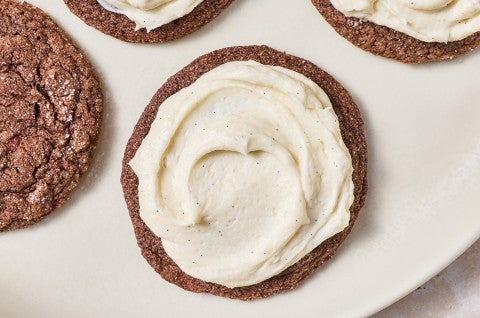 Top-down photograph of a soft chocolate sugar cookie that's been frosted. - select to zoom