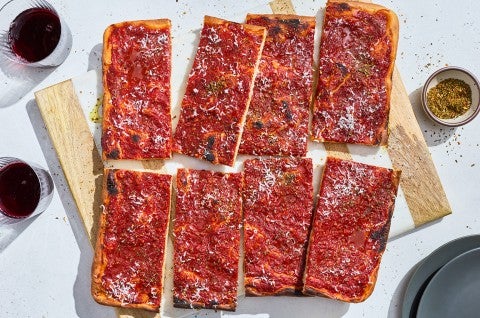 Rhode Island Pizza Strip sliced and arranged on a cutting board. - select to zoom
