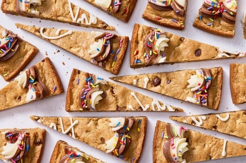 Slices of chocolate chip cookie cake arranged on a table. - select to zoom