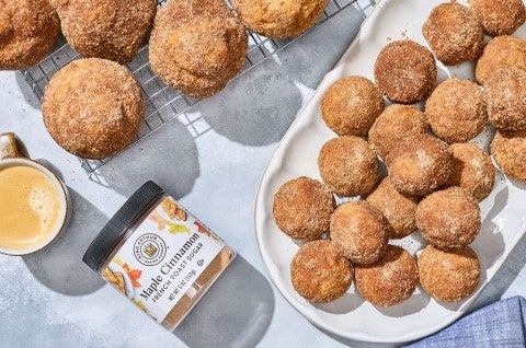 Maple French Toast Mini Muffins shown from above on a counter with a jar of King Arthur Maple Cinnamon. - select to zoom