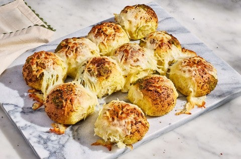 Fresh-baked Cheesy Pesto Pull-Apart Rolls shown on a marble platter - select to zoom