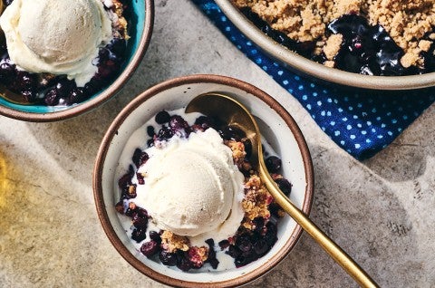 Blueberry Crisp in a round King Arthur Baking pie tin and also in a bowl topped with ice cream - select to zoom