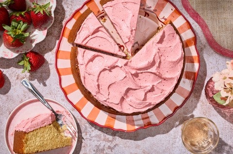 Brown Sugar Strawberry Frosted Cake sliced on a striped plate - select to zoom