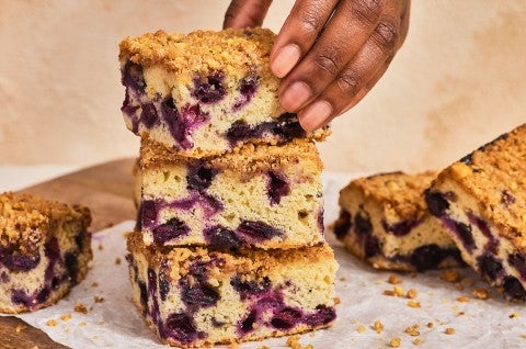 A stack of Emancipation Breakfast Cake slices with a hand placing the top slice - select to zoom