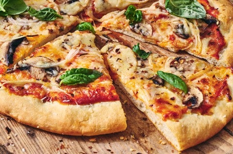 A slice of pizza slightly removed from a full pie - select to zoom