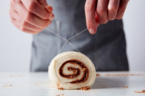 Slicing cinnamons rolls with dental floss