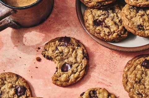 Whole Wheat Oatmeal Cookies on a plate with a mug of coffee and a cookie with a bite taken out on a counter seen from above - select to zoom