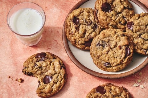Whole Wheat Oatmeal Cookies on a plate with a glass of milk and a cookie with a bite taken out on a counter seen from above - select to zoom