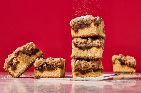 Apple Crumb Cake stacked in slices and shown against a dramatic red background - select to zoom