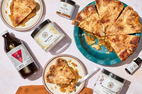 Apple pie and the ingredients to make it shown on a counter from overhead - select to zoom