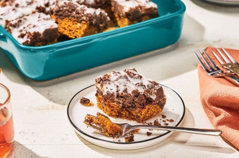 Chocolate Pumpkin Crumb Cake on a plate with a teal baking pan in the background - select to zoom