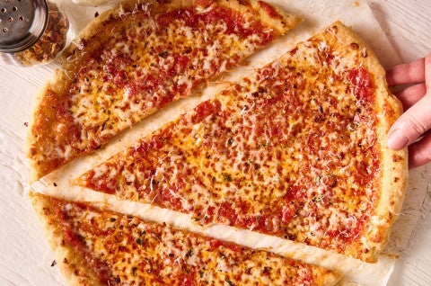 Removing a large slice of Gluten Free NY Style Pizza from the whole pie. - select to zoom
