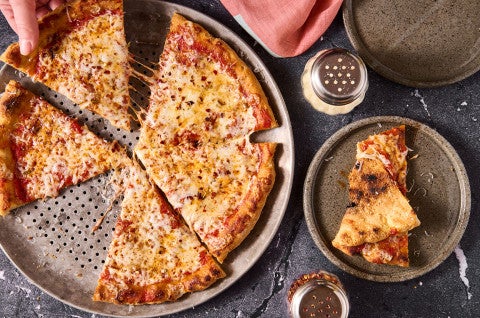 A Gluten Free NY Style Pizza on a pizza pan seen from above. - select to zoom
