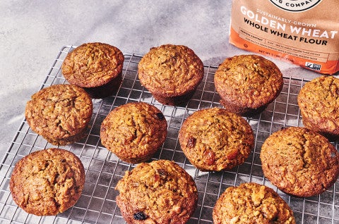 Morning Glory Muffins on a baking rack and a bag of King Arthur Baking Golden Wheat Flour in the background. - select to zoom