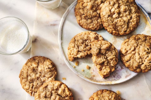 Oatmeal Cookies seen from above on a white plate with a glass of milk in the corner of the image - select to zoom