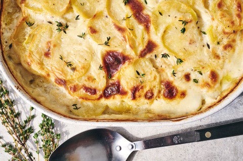 Scalloped Potatoes fresh out of the oven in a stoneware pan seen from above - select to zoom