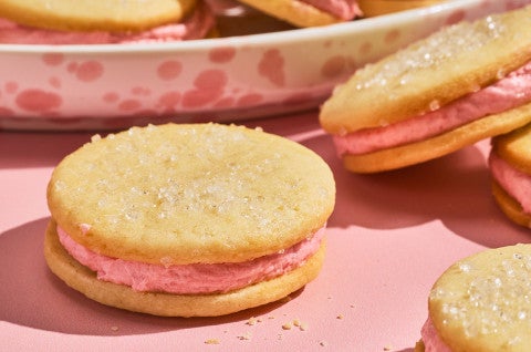Strawberry Shortcake Cookies on a pink counter seen from the side - select to zoom