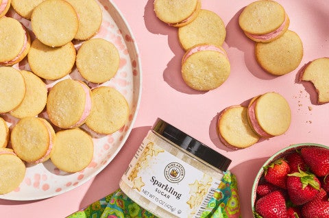 Strawberry Shortcake Cookies seen from above on a pink counter and stacked on a plate - select to zoom