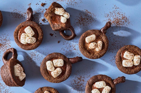 Hot Cocoa Cookie Cups arranged on a blue counter - seen from above. - select to zoom