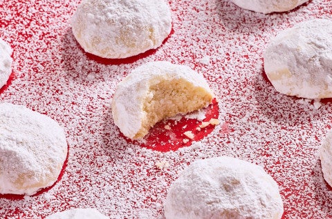 Lemon Snowball Cookies coated in powdered sugar on a red surface - select to zoom