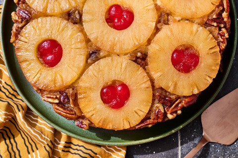 Pineapple Upside Down Cake seen from above with caremelized pineapple rings filled with maraschino cherries - select to zoom