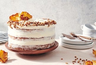 A Hummingbird Cake with a pineapple cream cheese frosting and dried pineapple and toasted nuts on top.