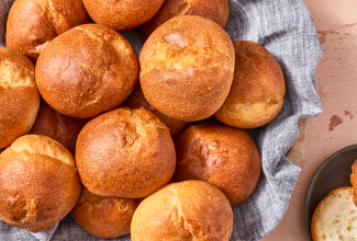 Freshly baked gluten-free rolls in a basket seen from above.