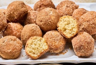 A group of Maple French Toast Mini Muffins with some broken in half to show the interior crumb.