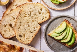No-Knead Sourdough Bread on a cutting board with some avocado toast