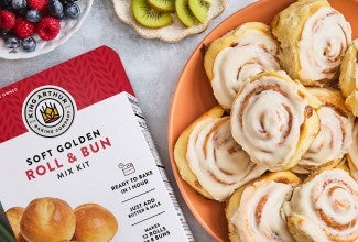 Cinnamon Rolls on a plate with a box of Roll & Bun King Arthur Baking mix