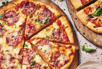 Two pizzas seen from above on wooden pizza peels