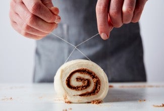 Slicing cinnamons rolls with dental floss