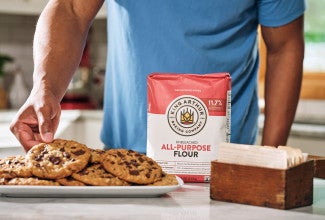 Grabbing an oatmeal chocolate chip cookie off a plate