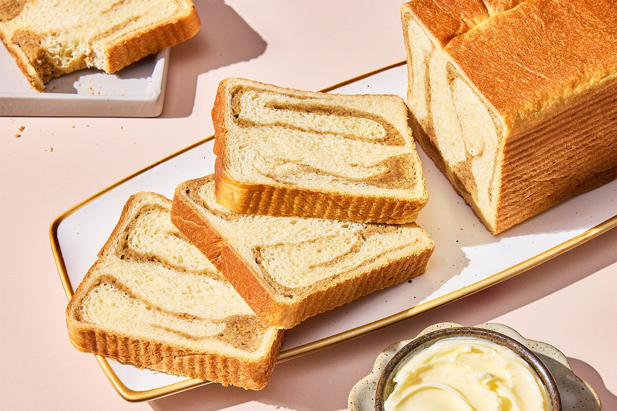 A sliced loaf of Swirled Maple Milk Bread on a serving tray
