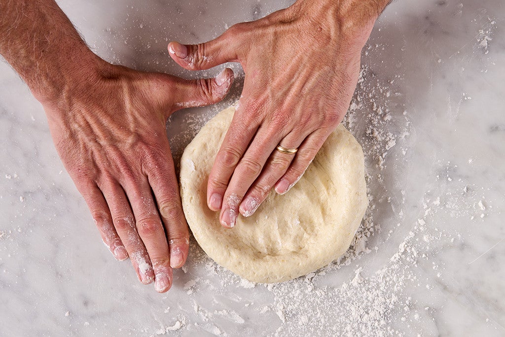 Shaping Gluten Free NY Style Pizza on a counter, seen from above.