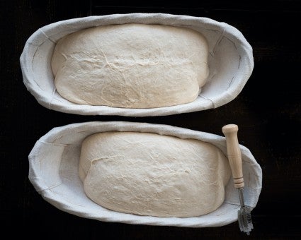 Two oval bannetons full of bread dough 