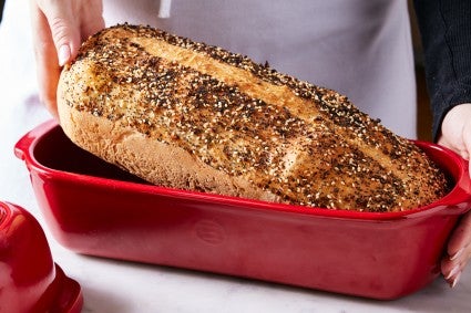Baker lifting loaf of bread out of pan