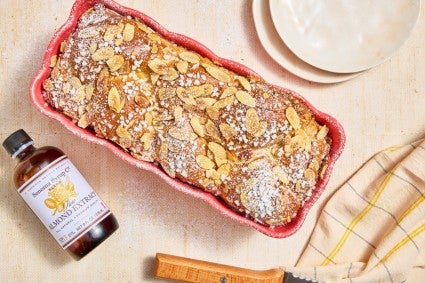 Almond Croissant Milk Bread in a pink rose pan with a bottle of almond extract on the side