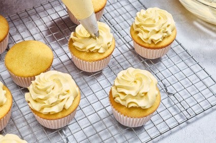 Piping French Buttercream onto cupcakes
