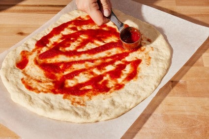 Saucing homemade pizza