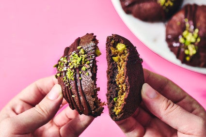 Breaking a Dubai Chocolate Cookie in half to show the filling