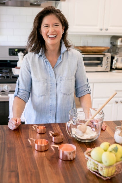 Headshot of Rezel Kealoha standing in her kitchen in front of a few baking tool