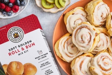 Cinnamon Rolls on a plate with a box of Roll & Bun King Arthur Baking mix