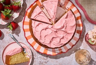 Brown Sugar Strawberry Frosted Cake sliced on a striped plate