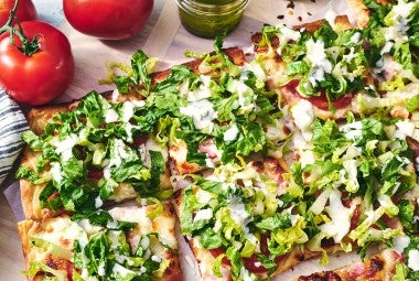 BLT Pizza sliced and covered with freshly chopped lettuce